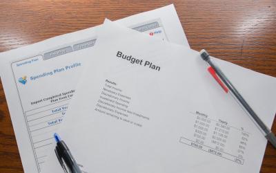 A family budget plan sitting on a desk with a pen and pencil.