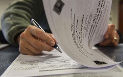 A man reviewing an information packet on creating a last will and testament.