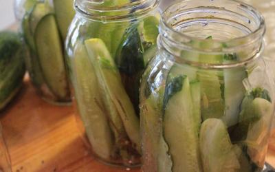 Three canning jars filled with cucumber slices.