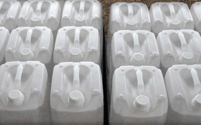 Rows of empty white, plastic pesticide containers.