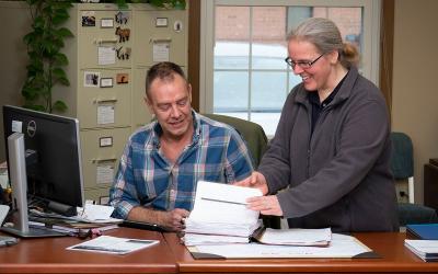 Producers reviewing paperwork in a farm office.