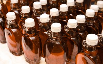 Bottles of maple syrup arranged on a table.