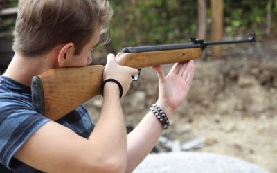 a young man shooting a rifle