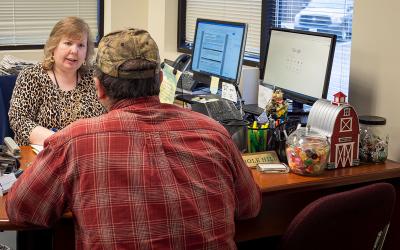 Female FSA employee reviewing paperwork with a male producer.