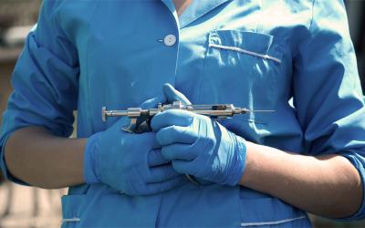 Veterinarian holding a syringe gun for animal vaccinations.