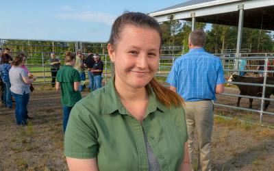 Young, female rancher hosting a small tour group.