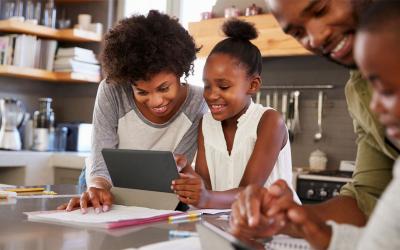 Family reviewing budget materials at a kitchen table.