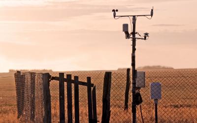 Weather station at the edge of a large, open pasture.