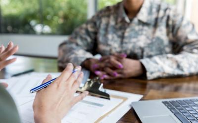 Instructor and female grant applicant reviewing paperwork at a table.