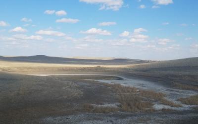 a dried up watering hole on the open prairie