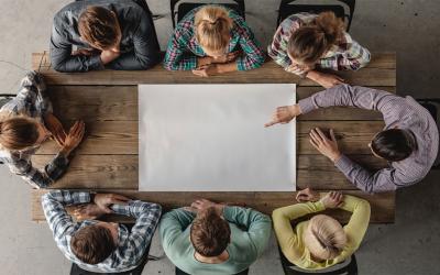 Small group of young professionals gathered around a meeting table.