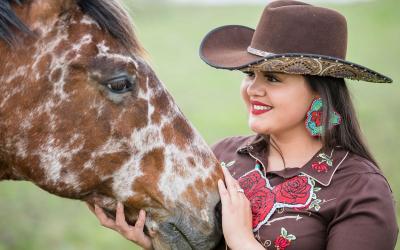 Tashina Red Hawk petting her horse.