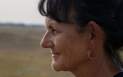 Female Native American rancher gazing into an open rangeland.