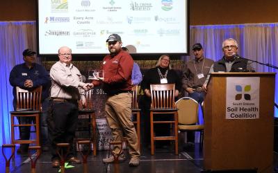 Anthony Bly, SDSU Extension Soils Field Specialist, receiving an award on-stage at the 2022 Soil Health Conference.