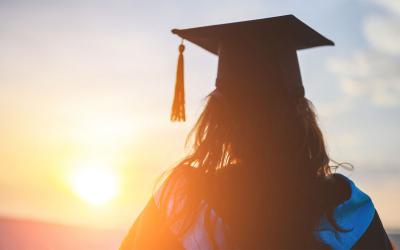 High school graduate watching a rural sunset.