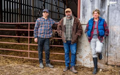 Family standing outside a cattle barn.