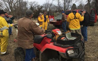 Tom Hausmann gives a briefing before the burn, while Greg Schmitz listens with the rest of the burn crew.