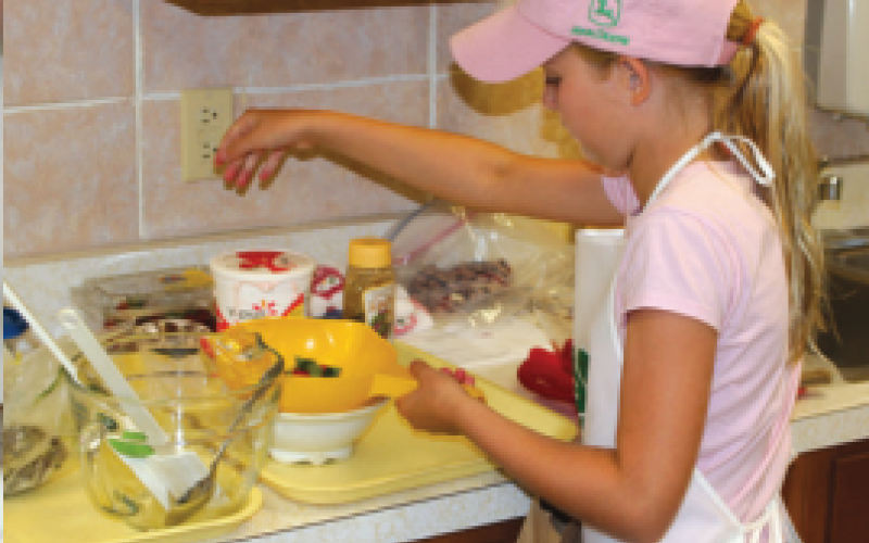 Youth girl cooking in kitchen.