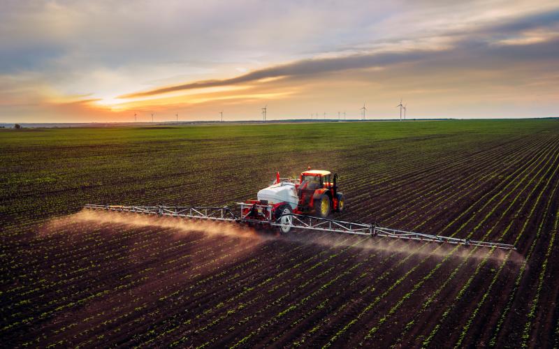 large multi-row sprayer adding chemicals to a field
