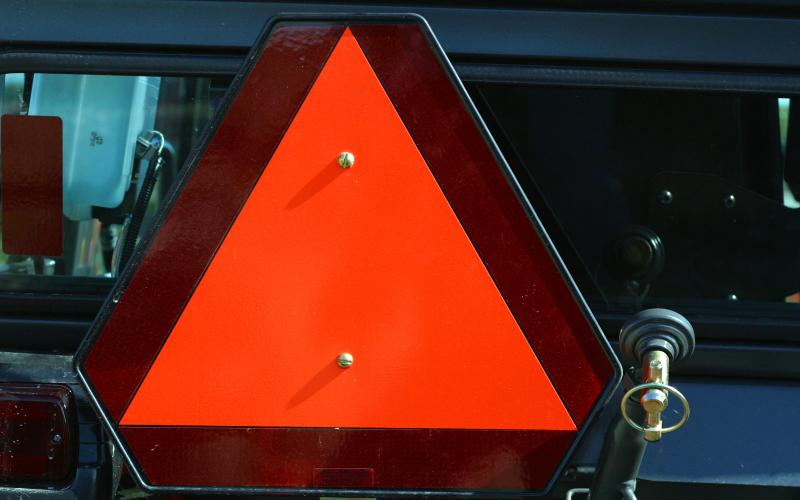 orange reflective safety triangle on a piece of farm equipment