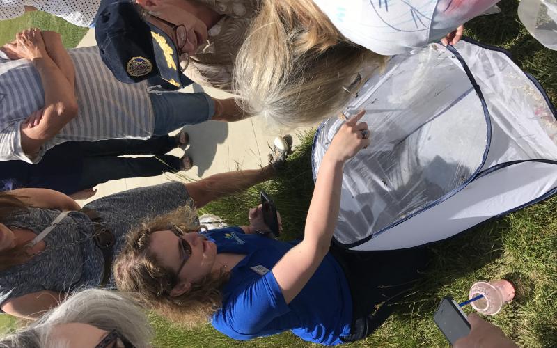 woman showing bugs to a group of adult learners