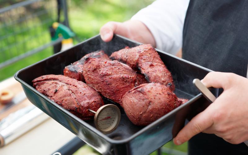 steaks in a pan with a meat thermometer