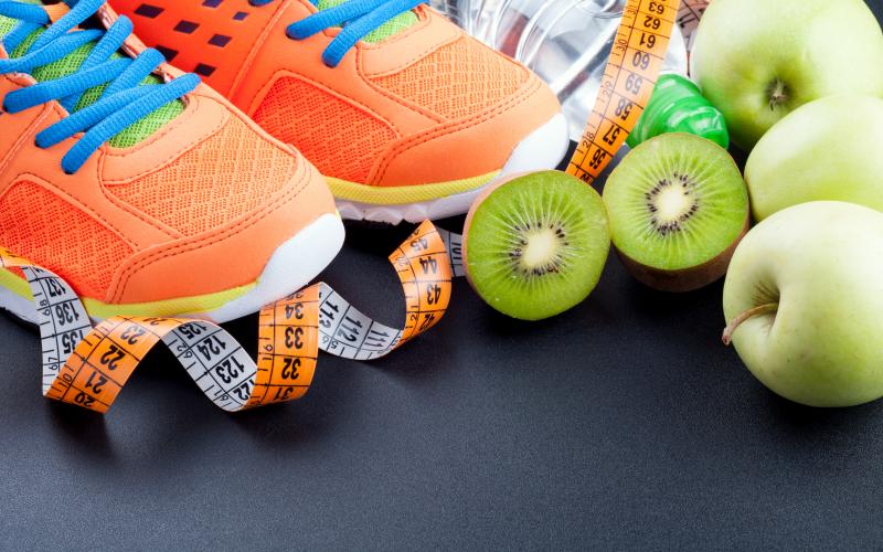 orange tennis shoes with fruit and a measuring tape