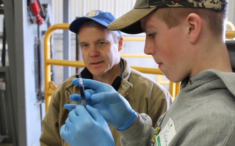 Nolan Dvorak learns how to correctly load a syringe under the supervision of Russ Daly