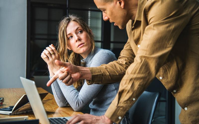 A young woman and her boss reviewing a project on a laptop.