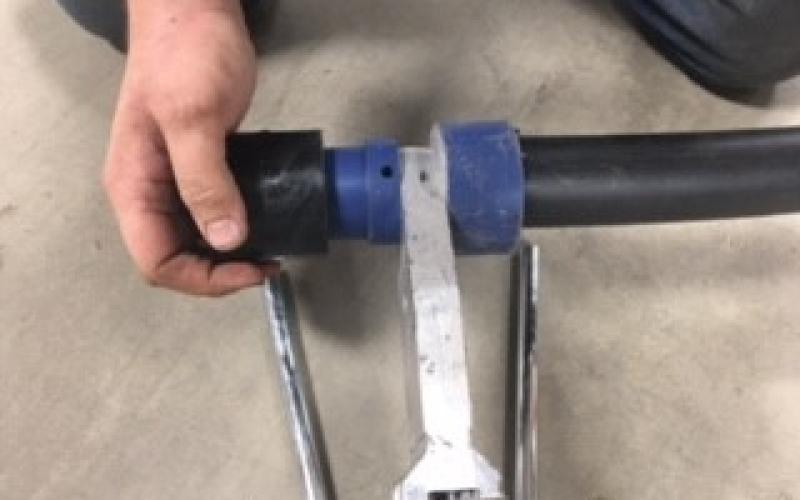 A hand displaying a welded pipe system joint.