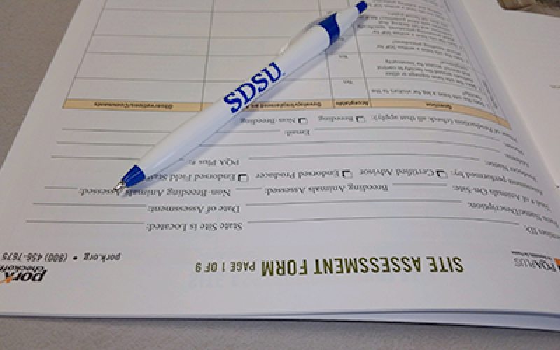 A site assesment form with a pen sitting on top.