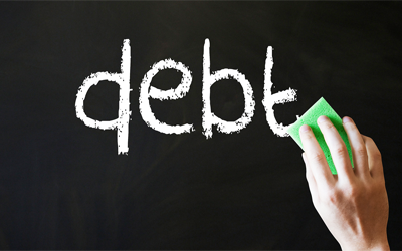 A chalkboard with "debt" written on it. Hand erasing the writing.