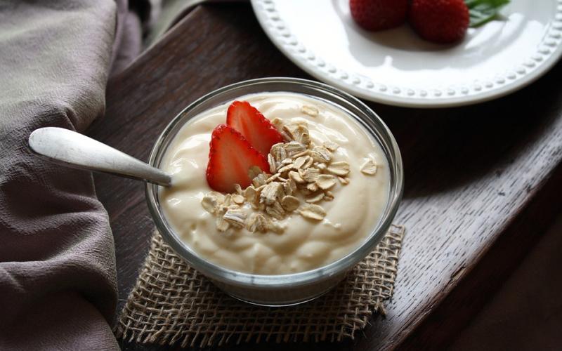 Fruit and yogurt in a glass with a spoon.