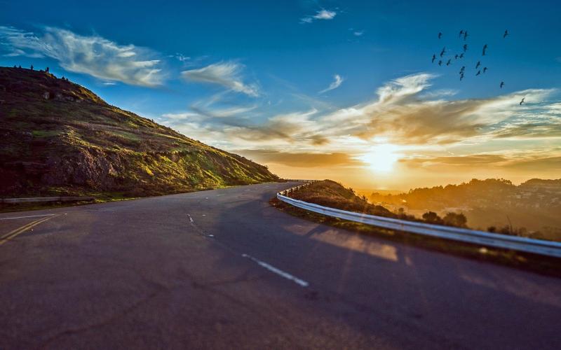 Sun rising over a country road.