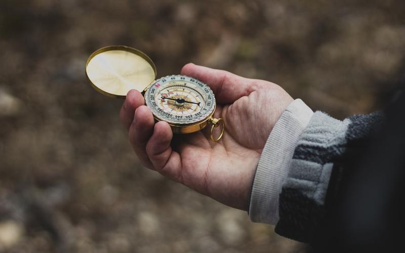 Hand holding a compass.