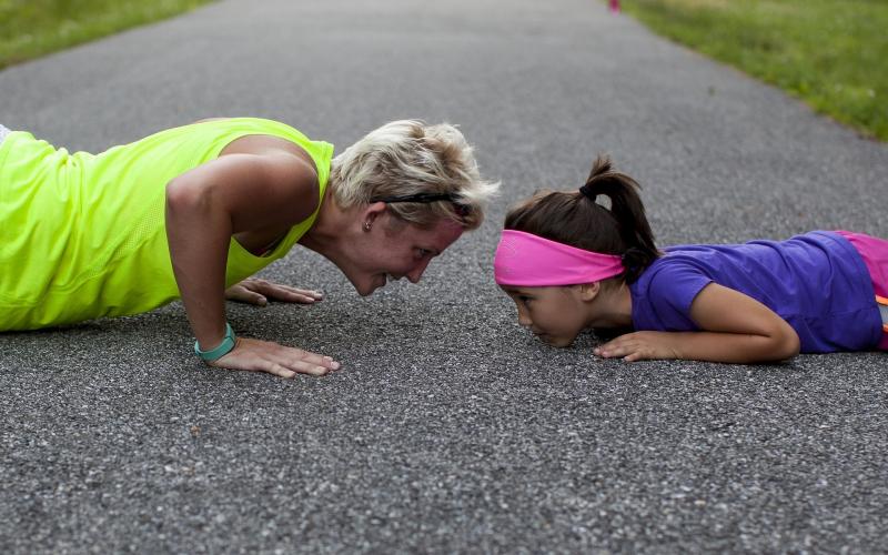 A mother and daughter doing pushups.