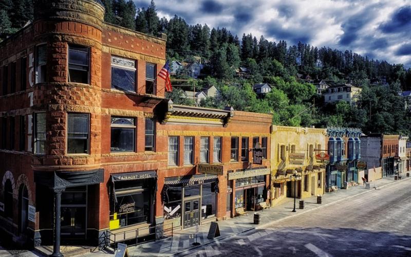 Downtown main street with storefronts and apartment buildings.
