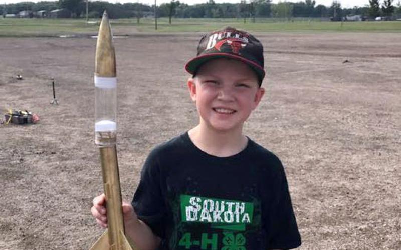 male 4-H youth holding a model rocket