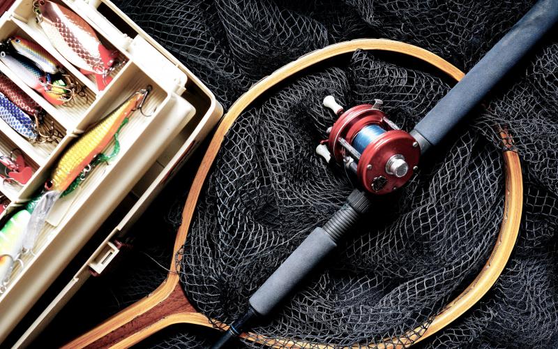 fishing net and rod next to tackle box