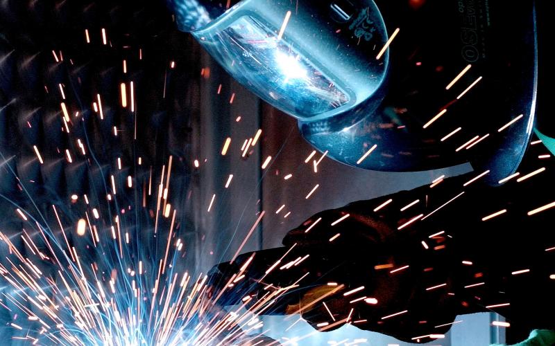 Man in welding mask welding metal pieces together