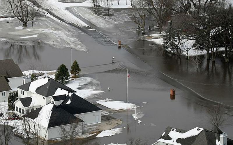 neighborhood street flooded with melted snow and water runoff. FEMA News Photo