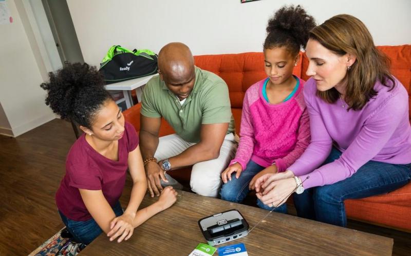 family gathered around an emergency weather radio