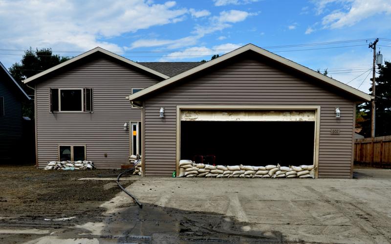 Outside of a home impacted by flooding. Sandbags ar in front of windows and the garage. Photo by David Valdez, FEMA