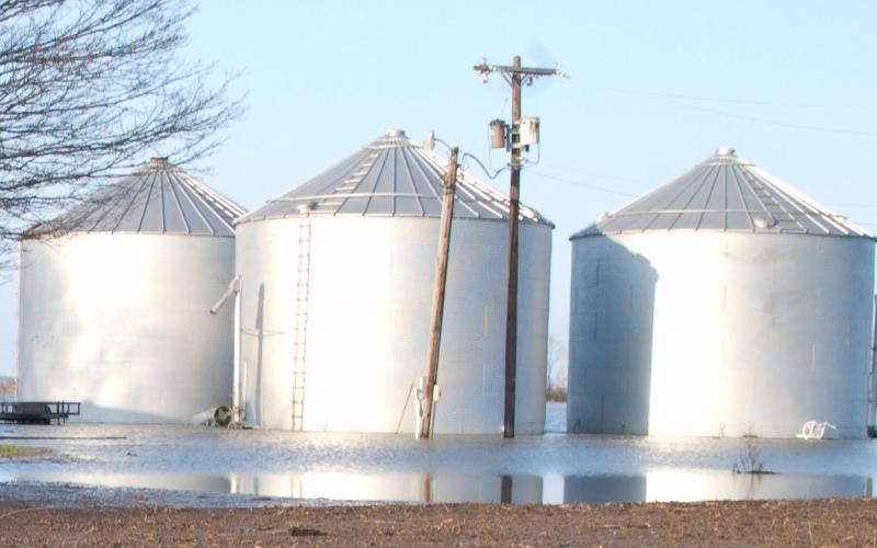 three grain bins in a flooded farm yard. Photo by John Shea, FEMA