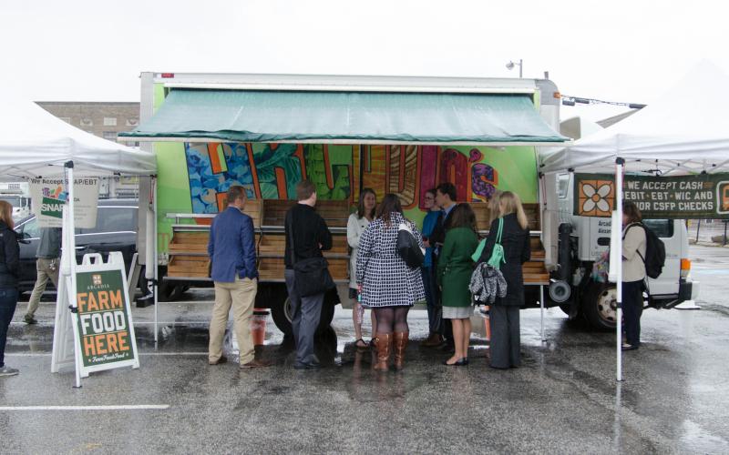 small group of people outside a mobile food hub. Photo by Shakeitha Stone, USDA
