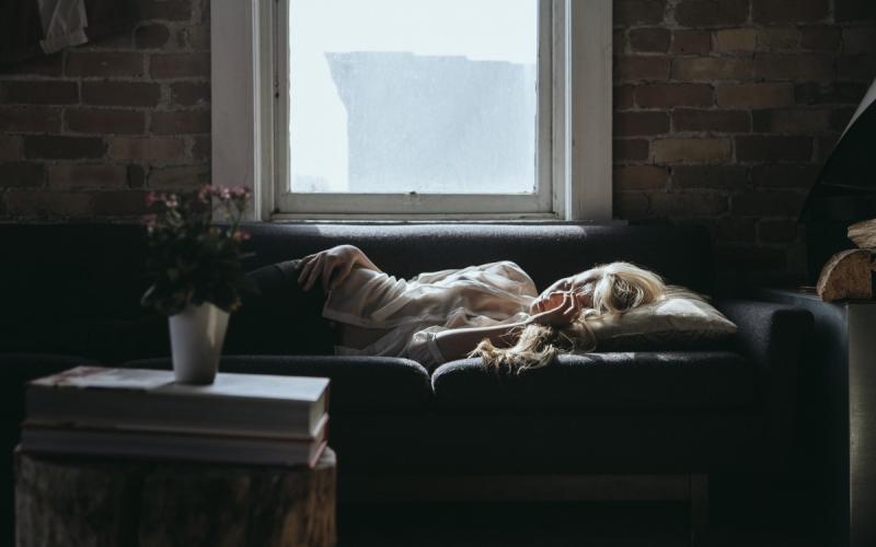 a sick woman layingon a couch