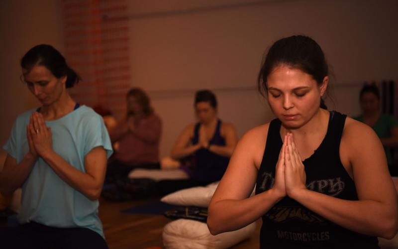 group of young women meditating during a yoga session