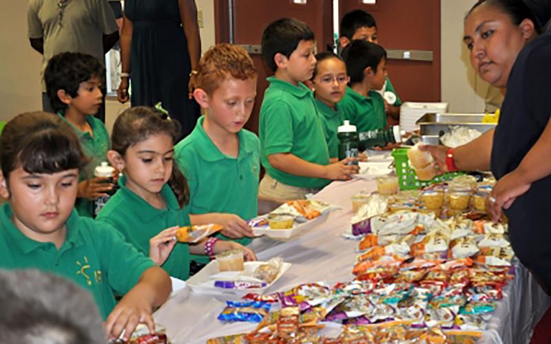 Group of young children receiving a free meal at a lunch station. Courtesy: USDA