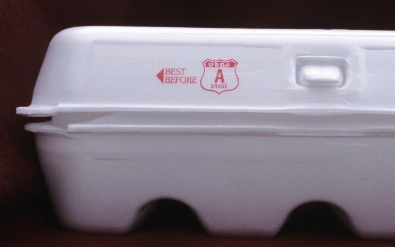 A white egg carton against a black background. The carton has read text reading, "Best Before" along with a red seal reading "USDA 'A' Grade".