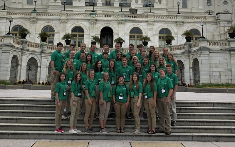 a group of young people standing in front of the US Capitol building